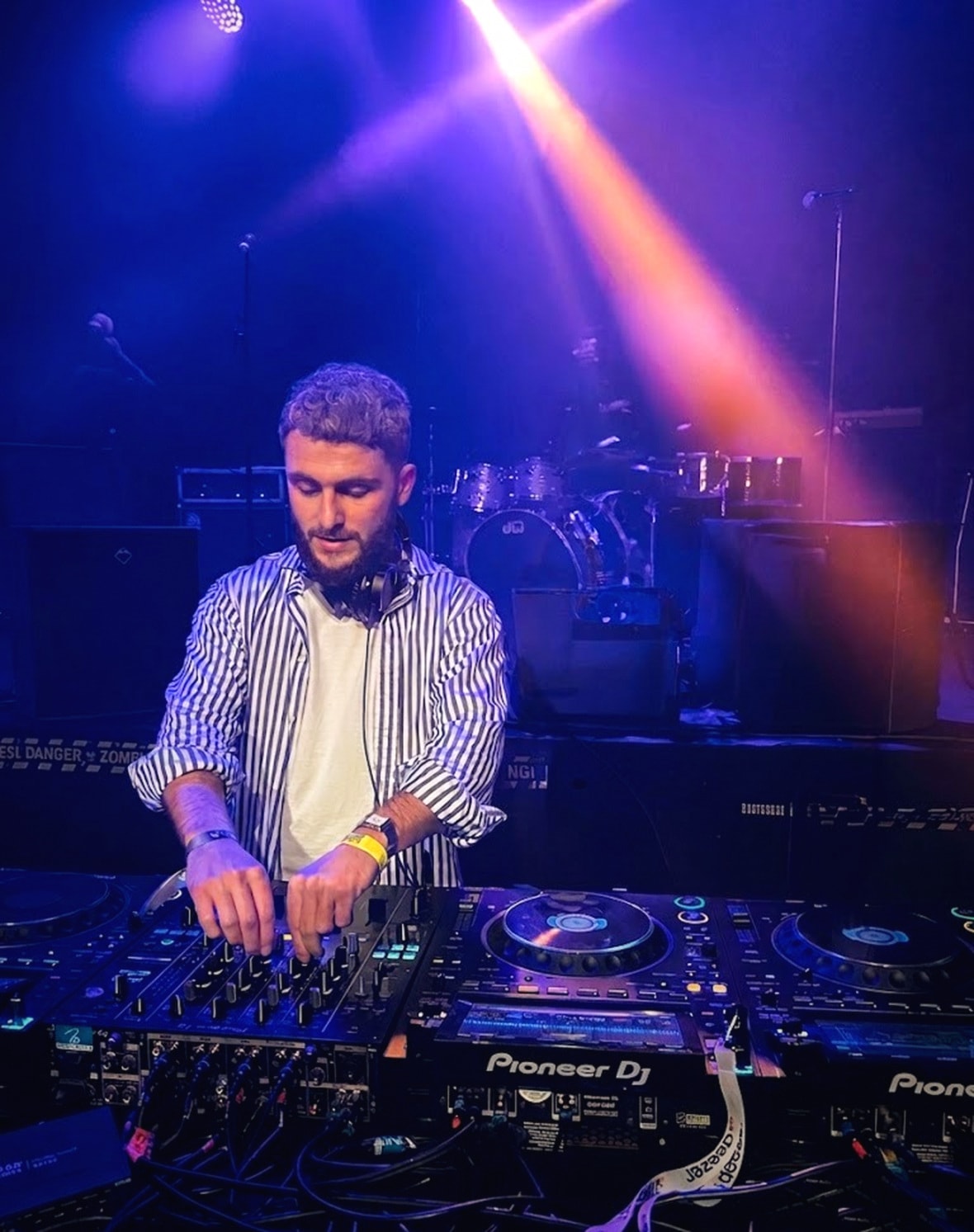 JANORIS behind the decks under purple and blue club light