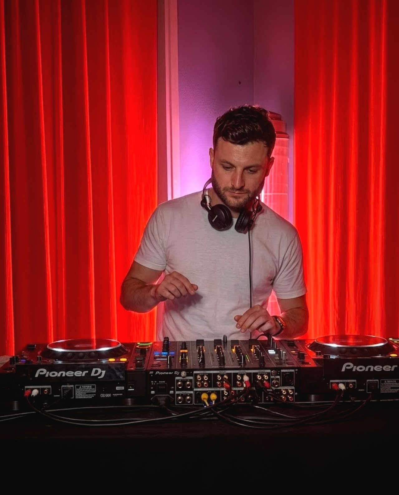 JANORIS playing a live set, framed by warm red stage drapes