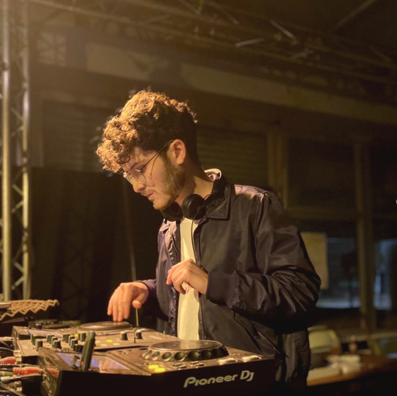 JANORIS behind the decks in warm, low golden light